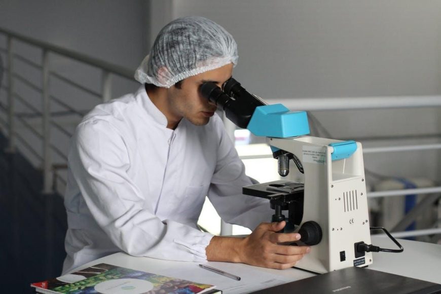 A medical professional looking into a microscope
