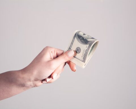 Woman's hand holding a dollar bills